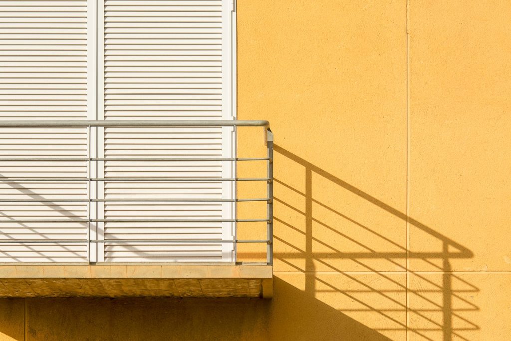 Schlichtes Stahlgeländer an einem Balkon im Sonnenlicht