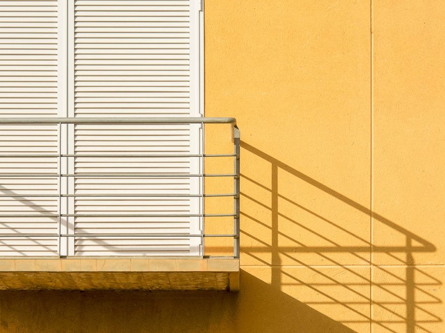 Schlichtes Stahlgeländer an einem Balkon im Sonnenlicht